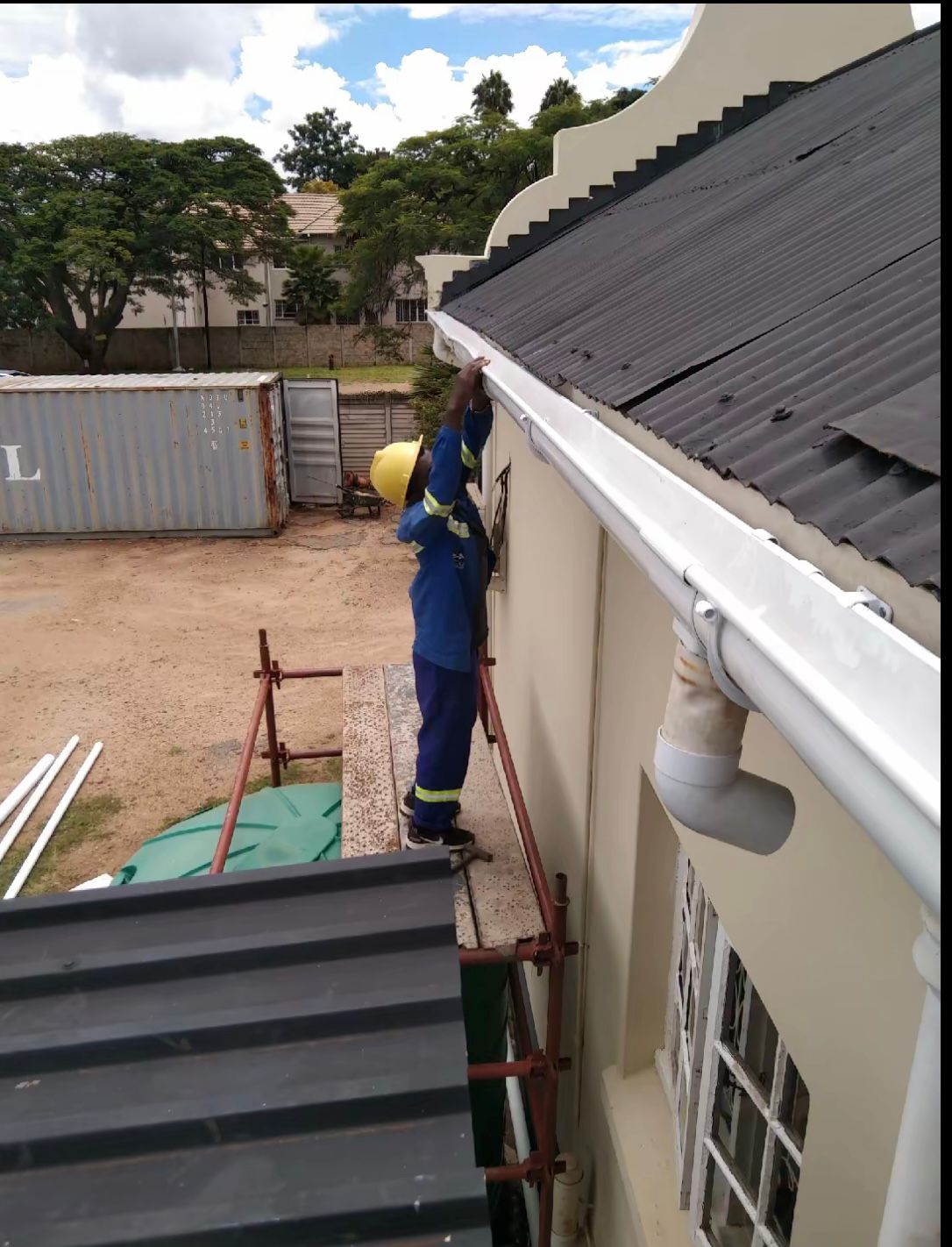 Wozoli technician installing seamless gutters on a residential property